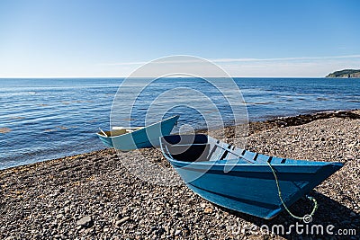 Wooden fishing boats on the sea pebble beach Stock Photo