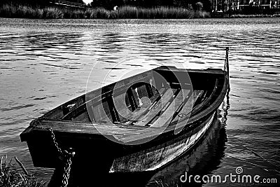 Wooden fishing paddle boat closeup anchored on the shore. monochrome finish Stock Photo
