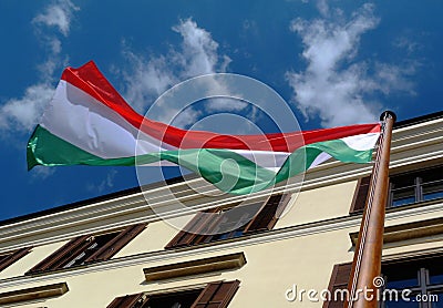 Wooden flag pole in diminishing perspective. red, white and green Hungarian national flag. blue sky Stock Photo