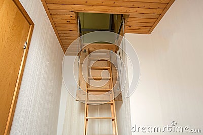 Wooden folding ladder to the attic, old empty house Stock Photo