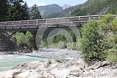 wooden footbridge over a fast flowing mountain river Stock Photo
