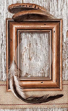 Wooden frame, burlap ribbon and feathers on the old wood Stock Photo