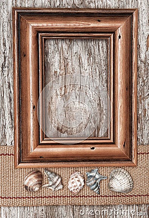 Wooden frame, burlap ribbon and seashells on the old wood Stock Photo