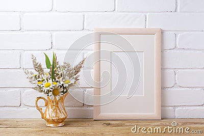 Wooden frame mockup with chamomile and grass in golden pitcher Stock Photo