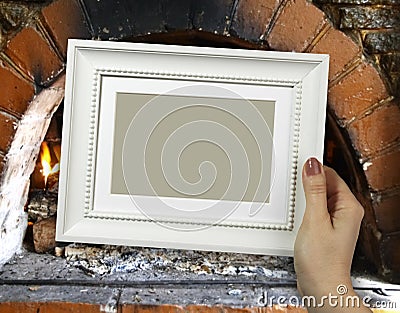 Wooden frame in woman hands. Warm Hearth on the background Stock Photo