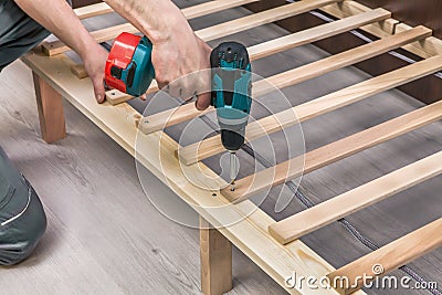 Wooden furniture assembling- woodworker screwing screws Stock Photo