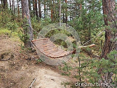 A wooden hammock in the woods on a sunny day is quite a restful place. Stock Photo