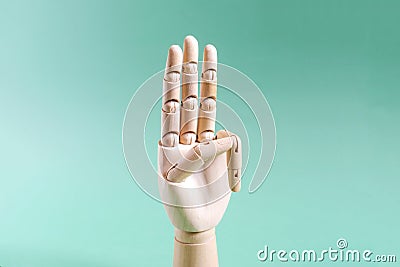 The wooden hand gesture shows three fingers up . The concept is a wooden hand showing the number three in close-up Stock Photo