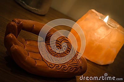 Wooden Hand with Henna Engravings and a Himalayan Rock Salt Candle Stock Photo