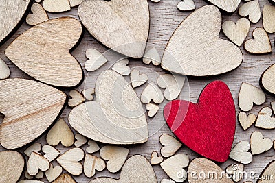 Wooden hearts, one red heart on the heart background. Stock Photo