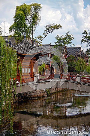 Wooden houes in Chinese style, picturesque bridge across the river in China Stock Photo