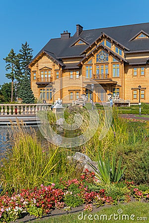 A wooden house with balconies in a beautiful park near an artificially created lake Stock Photo