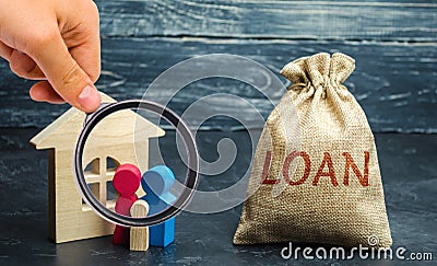 Wooden house with family and a bag with the word Loan. Buying a home in debt. Family investment in real estate and risk management Stock Photo