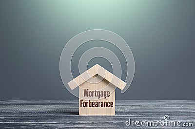 Wooden house figurine with inscription Mortgage forbearance. Borrower and lender agreements reduce or suspend mortgage loan Stock Photo