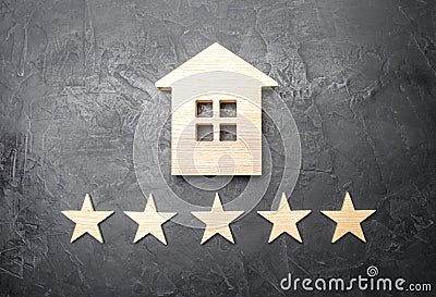 Wooden house and five stars on a gray background. Rating of houses and private property. Buying and selling, renting apartments Stock Photo