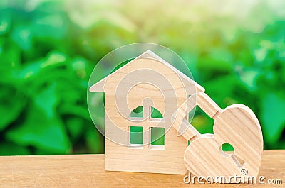 Wooden house with Heart shaped lock on a green bokeh background. Love nest, relationships. Buying a house with a young family. Stock Photo