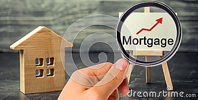 Wooden house and the inscription Mortgage and up arrow. Raising mortgage rates and tax. The increase in interest charges. Reduced Stock Photo