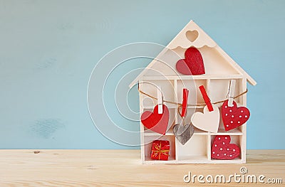 Wooden house with many hearts on the table Stock Photo