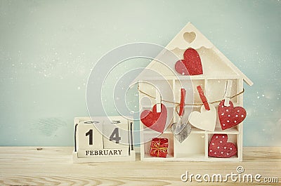 Wooden house with many hearts on the table Stock Photo