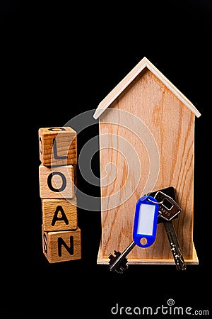 wooden house mockup with house keys, wooden cubes with words rent sale , buy and loan. on black background Stock Photo