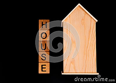 wooden house mockup with house keys, wooden cubes with words rent sale , buy and loan. on black background Stock Photo