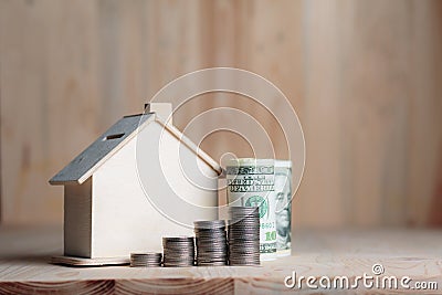 Wooden house piggy bank with dollar money and coin on wooden tab Stock Photo