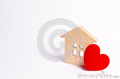 Wooden house with a red heart on a white background. Love nest, love relationships. Buying a house with a young family. Stock Photo