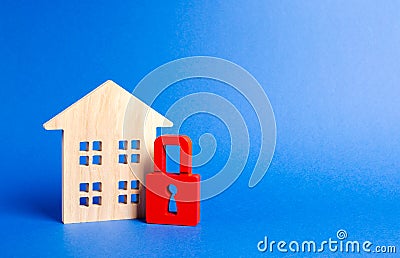 Wooden house and a red padlock. Security and safety. Unavailable and expensive real estate. house Insurance Confiscation for debts Stock Photo