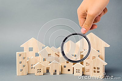 Wooden houses and magnifying glass. Property valuation. Home appraisal. Choice of location for the construction. House searching Stock Photo