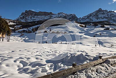 Wooden Houses, Mountains and Fresh Snow in Europe: Dolomites Alps Peaks in Winter Stock Photo