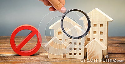 Wooden houses and a prohibition sign. Inaccessible and expensive housing. Restrictions and a ban on the construction of buildings Stock Photo