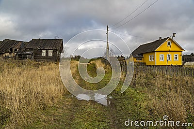 Wooden houses stand opposite each other along the village road. Stock Photo