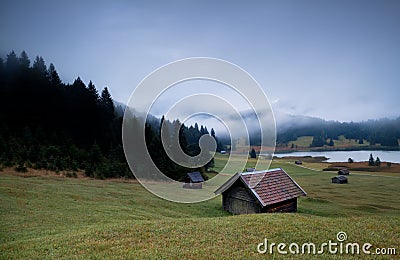 Wooden huts and fog over Geroldsee lake in dusk Stock Photo