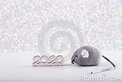 Wooden icon with 2020 digits and little toy gray mouse - Chinese symbol of New Year on white glitter sparkling background with Stock Photo