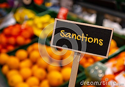 Wooden information label sign with text SANCTIONS against defocused store shelves message. Global hunger, inflation Stock Photo