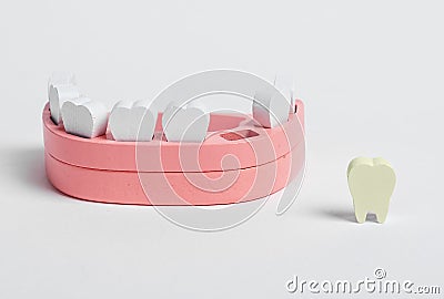 Wooden jaw model and fallen out bad tooth with plaque, cavity. Teeth diseases, inflammation, poor oral hygiene concept Stock Photo