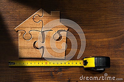 Wooden Jigsaw Puzzle Pieces Forming a House Shape Stock Photo