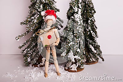Jointed mannequin doll holding holiday Christmas present on winter scene Stock Photo
