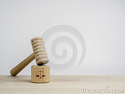 A wooden judge gavel with words, ethics, respect, honesty, and integrity with the soundboard with scales icon. Stock Photo