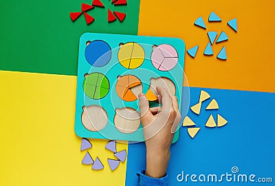 Wooden kids toys on colourful paper. Educational fractions. Toys for kindergarten, preschool or daycare. Stock Photo