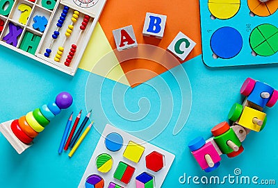 Wooden kids toys on colourful paper. Educational toys blocks, numbers, letters, train. Toys for kindergarten, preschool Stock Photo