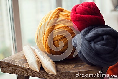 Wooden knitting needles and merino wool balls, lying on wooden s Stock Photo