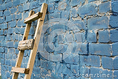 Wooden ladder against wall Stock Photo