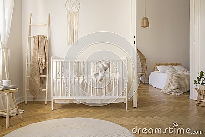 Wooden ladder with beige blanket white crib real photo Stock Photo