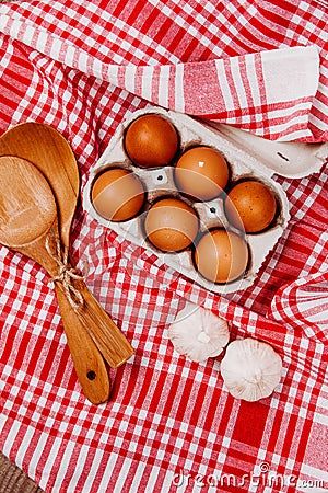 Wooden ladles and eggs on a red and white table rug Stock Photo