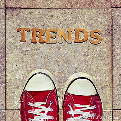 Wooden letters forming the word trends and the feet of a young m Stock Photo