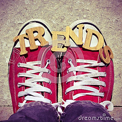 Wooden letters forming the word trends and the feet of a young man Stock Photo
