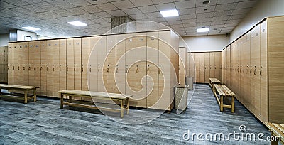 Wooden lockers with a wood bench in a locker room Stock Photo