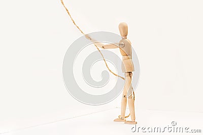 A wooden manequin toy holding holding a thin rope in his hand Stock Photo