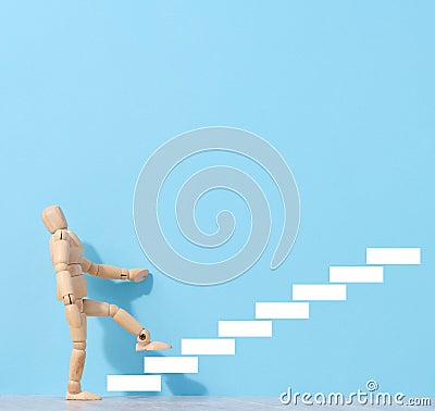 A wooden mannequin and drawn steps going up, a concept of achieving a goal, strong personality Stock Photo